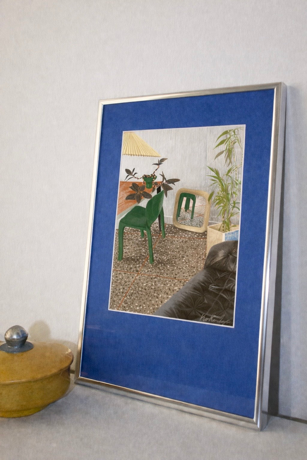 HIS ROOM IS “ON POINT" // FINE ART PRINT con silla verde, plantas, suelo de mosaico y sofá oscuro en sala moderna