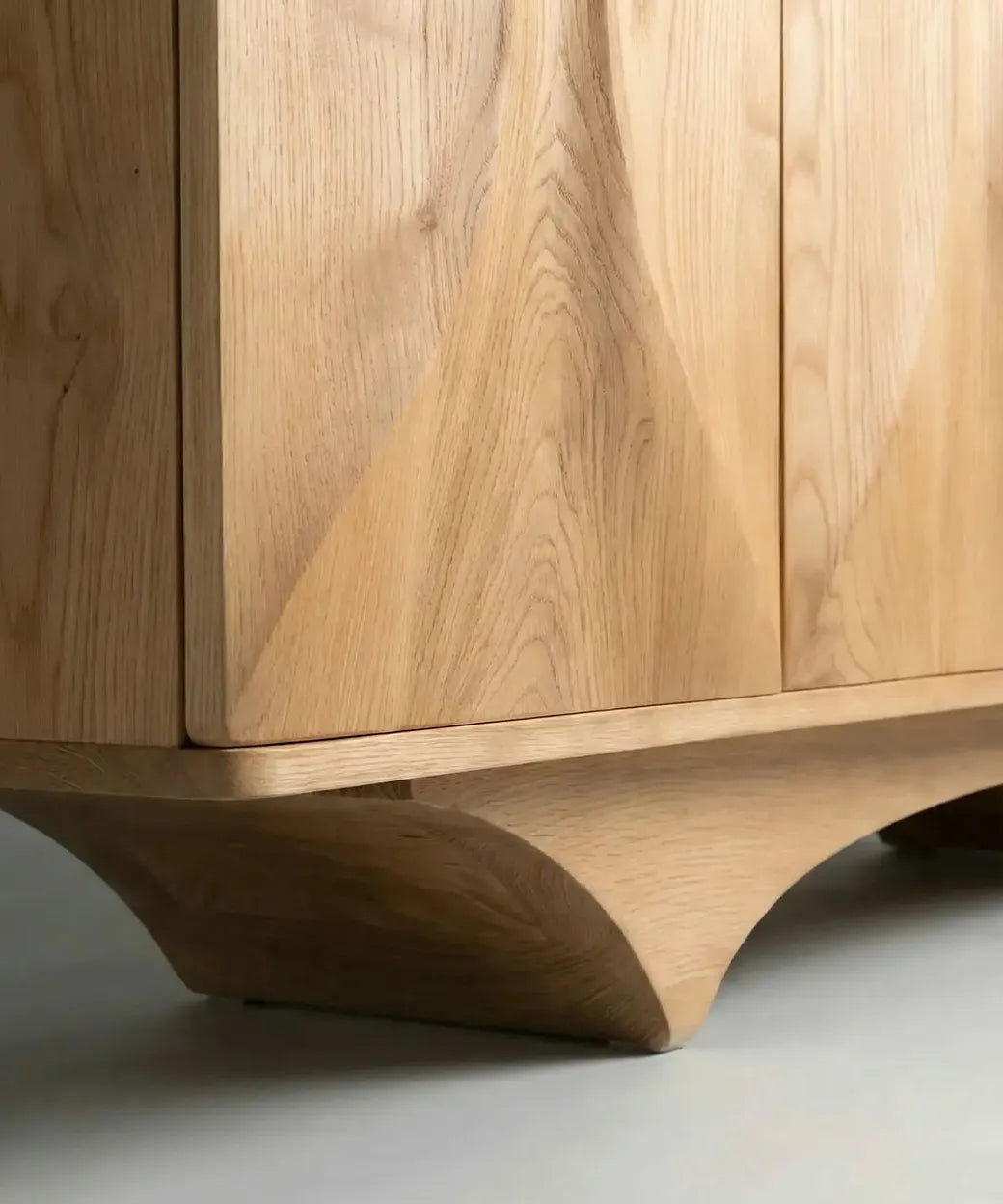 Aday en madera natural con base curvada que aporta un diseño contemporáneo y elegante con vetas definidas.