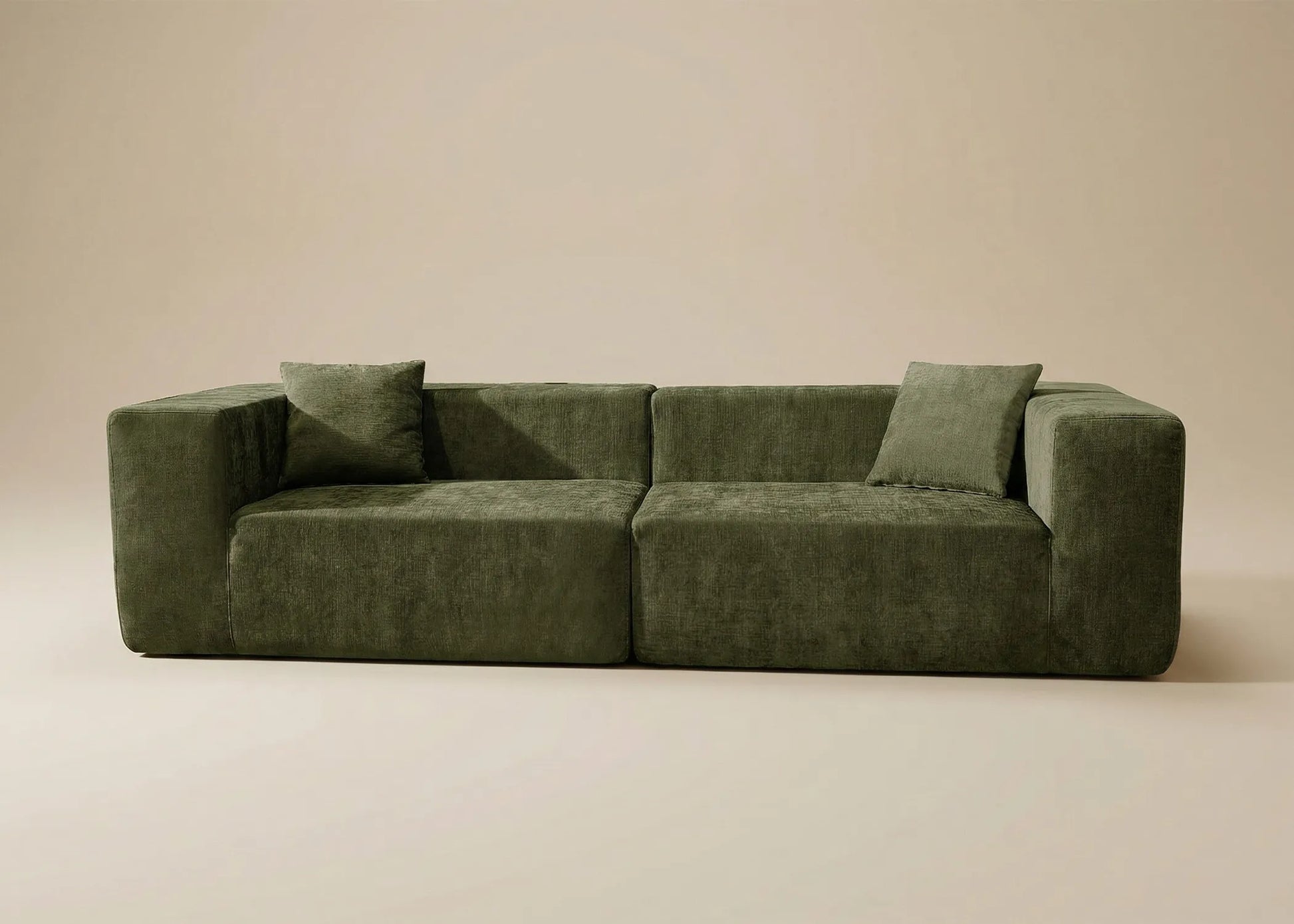 Sofá Naos en tono verde oscuro, con diseño robusto y formas imponentes que llaman la atención al centro del espacio