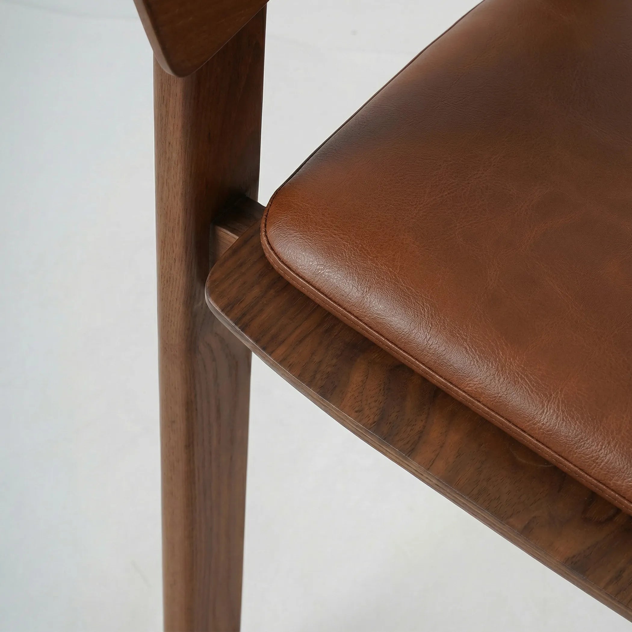 Silla Sabina de comedor en madera de fresno con asiento tapizado en tono marrón, diseño contemporáneo y líneas suaves.