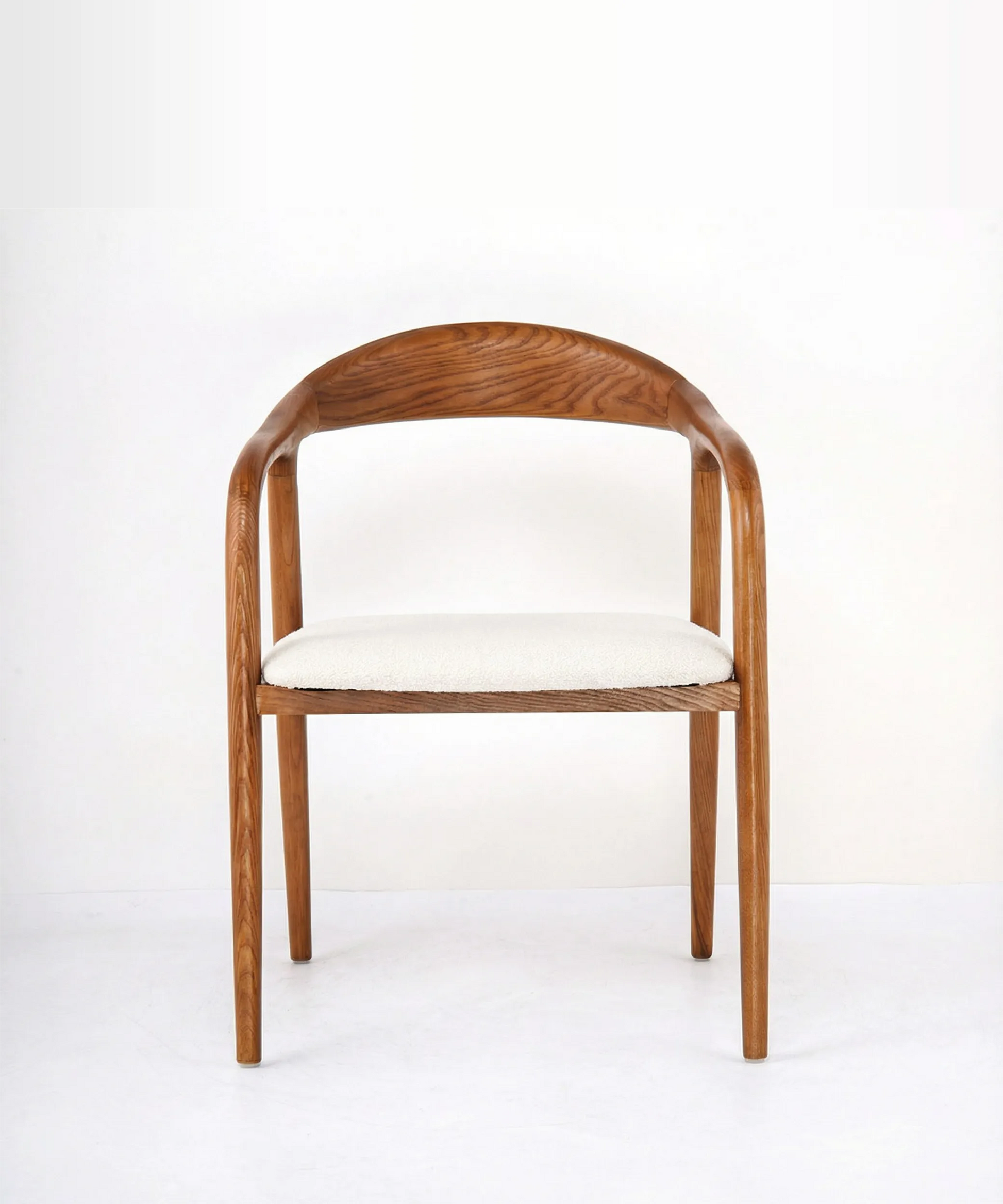 Silla Tabaiba en madera de fresno con diseño orgánico y asiento tapizado en tono claro para comedor contemporáneo.