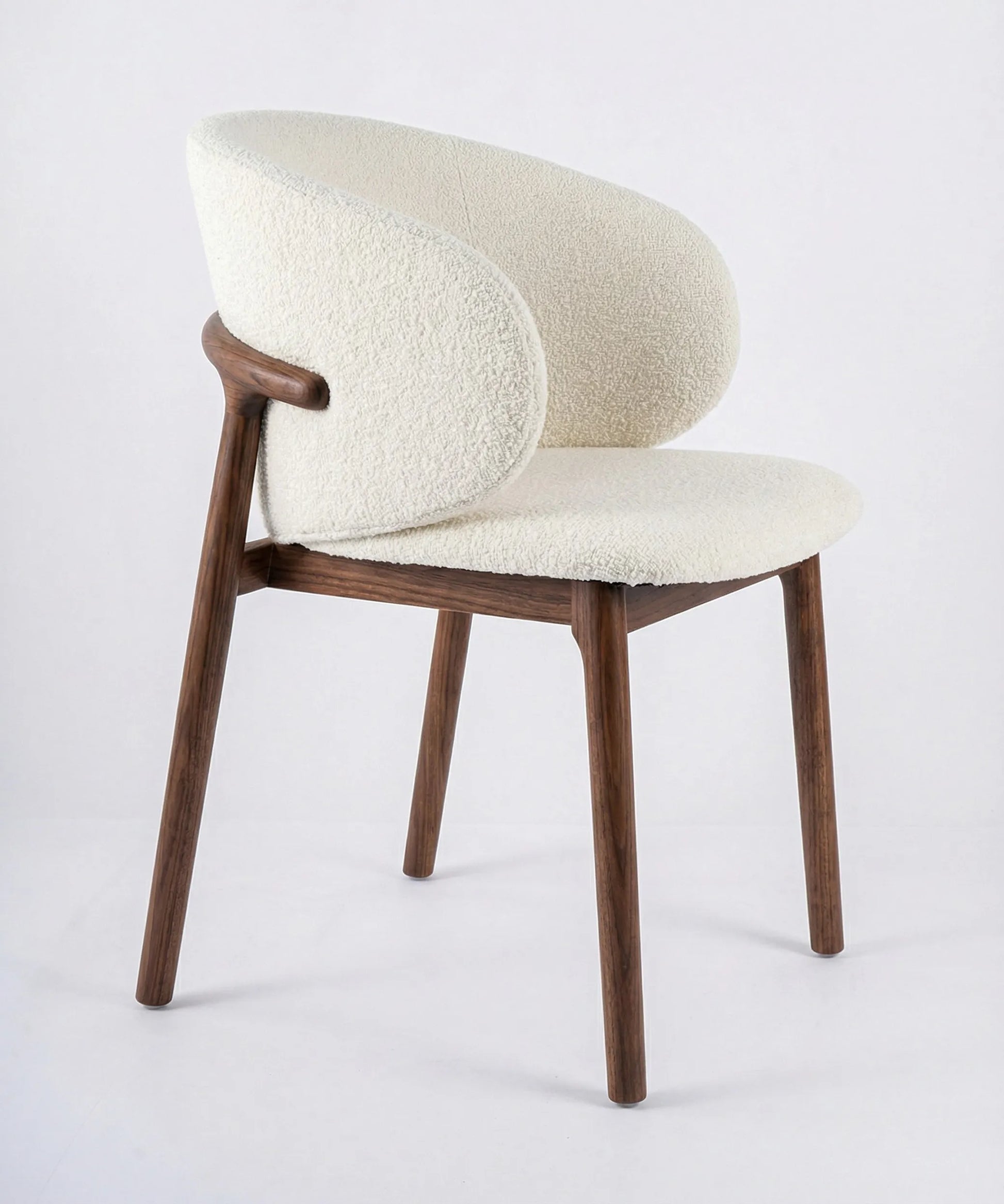 Silla Laurisilva de comedor en madera de fresno con diseño envolvente y tapizado suave color blanco crema.