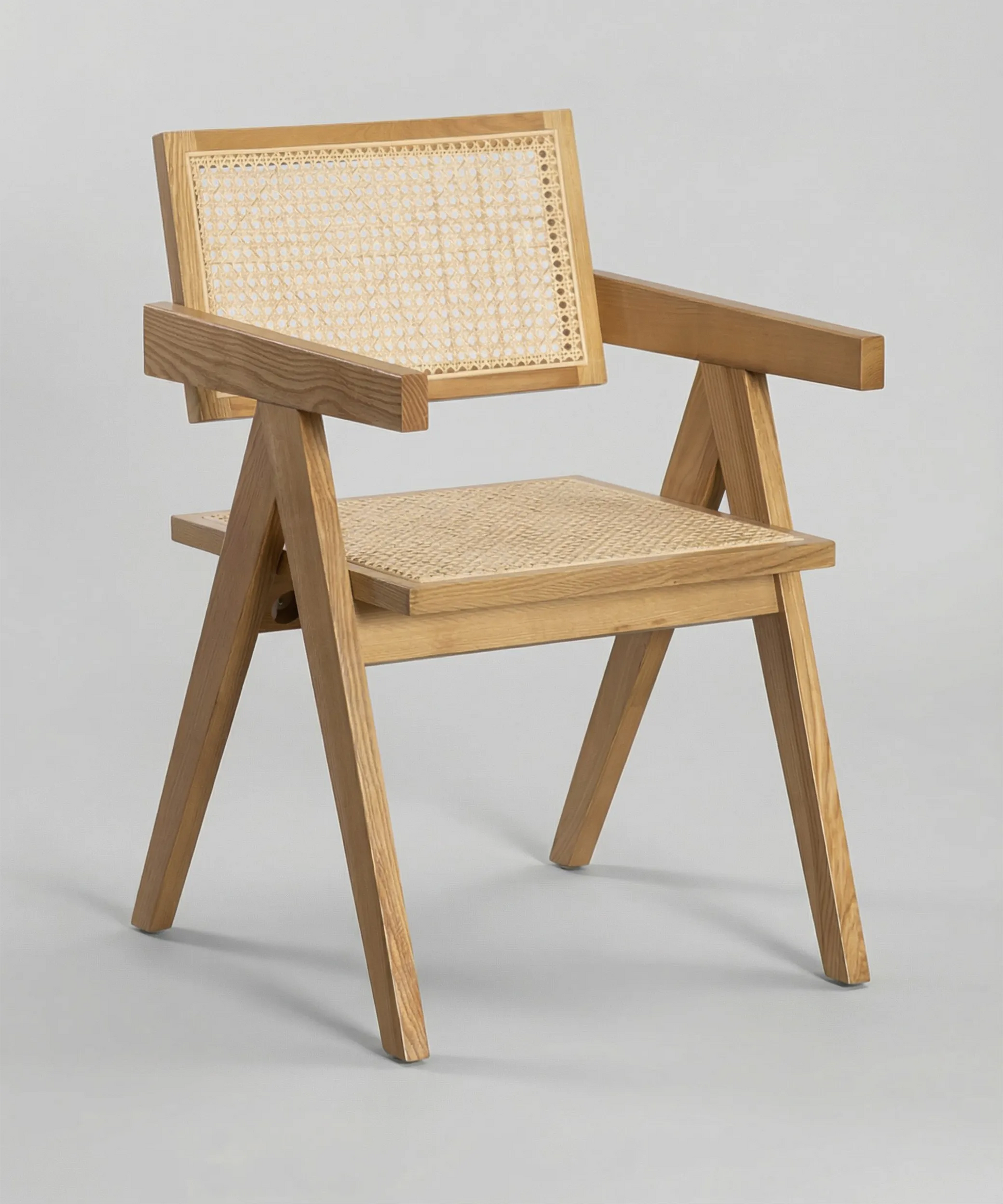 Silla Retama de diseño nórdico con estructura geométrica en madera clara y asiento de mimbre natural.