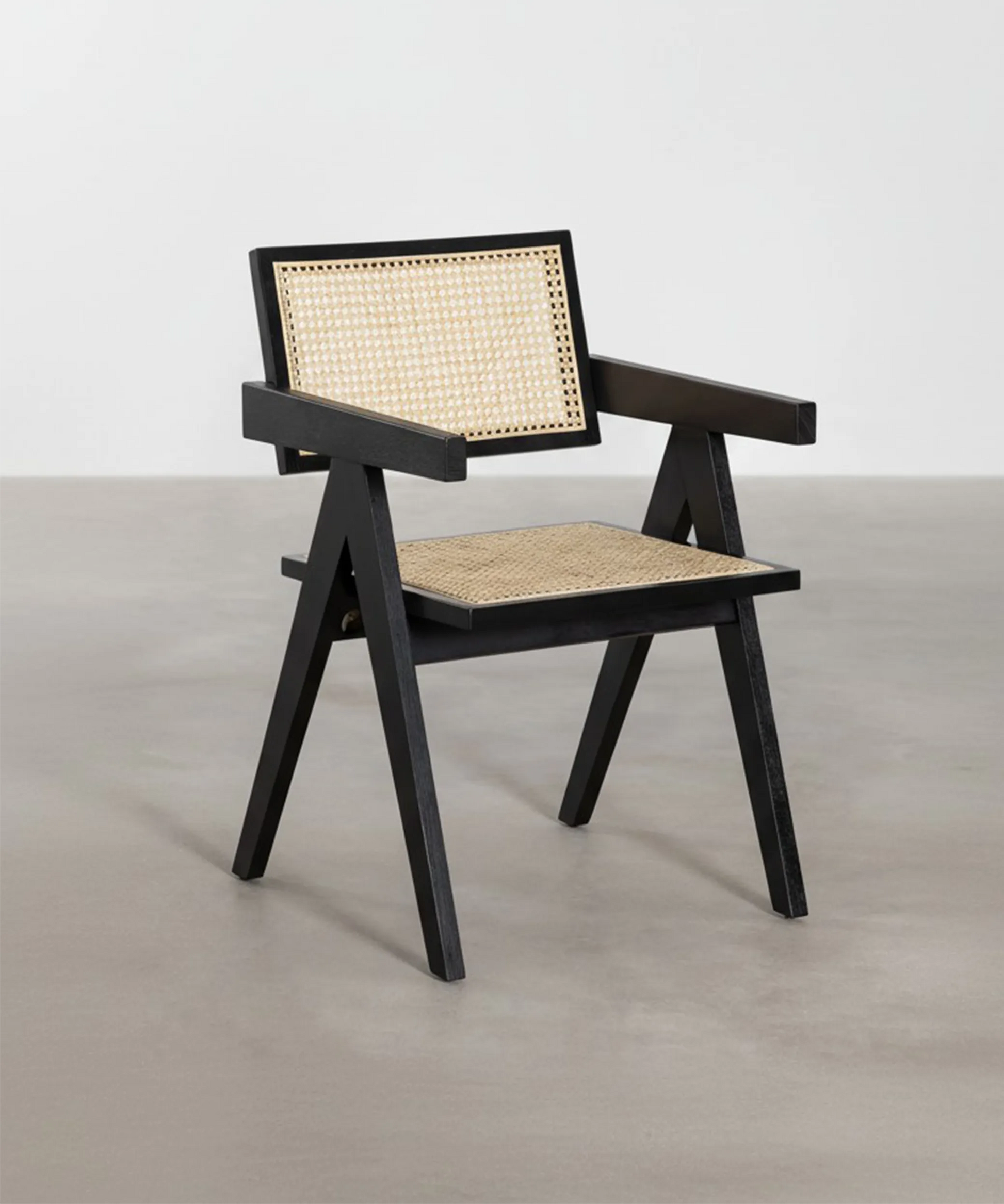 Silla Retama con estructura geométrica en madera negra y asiento trenzado, diseño nórdico contemporáneo elegante y funcional.
