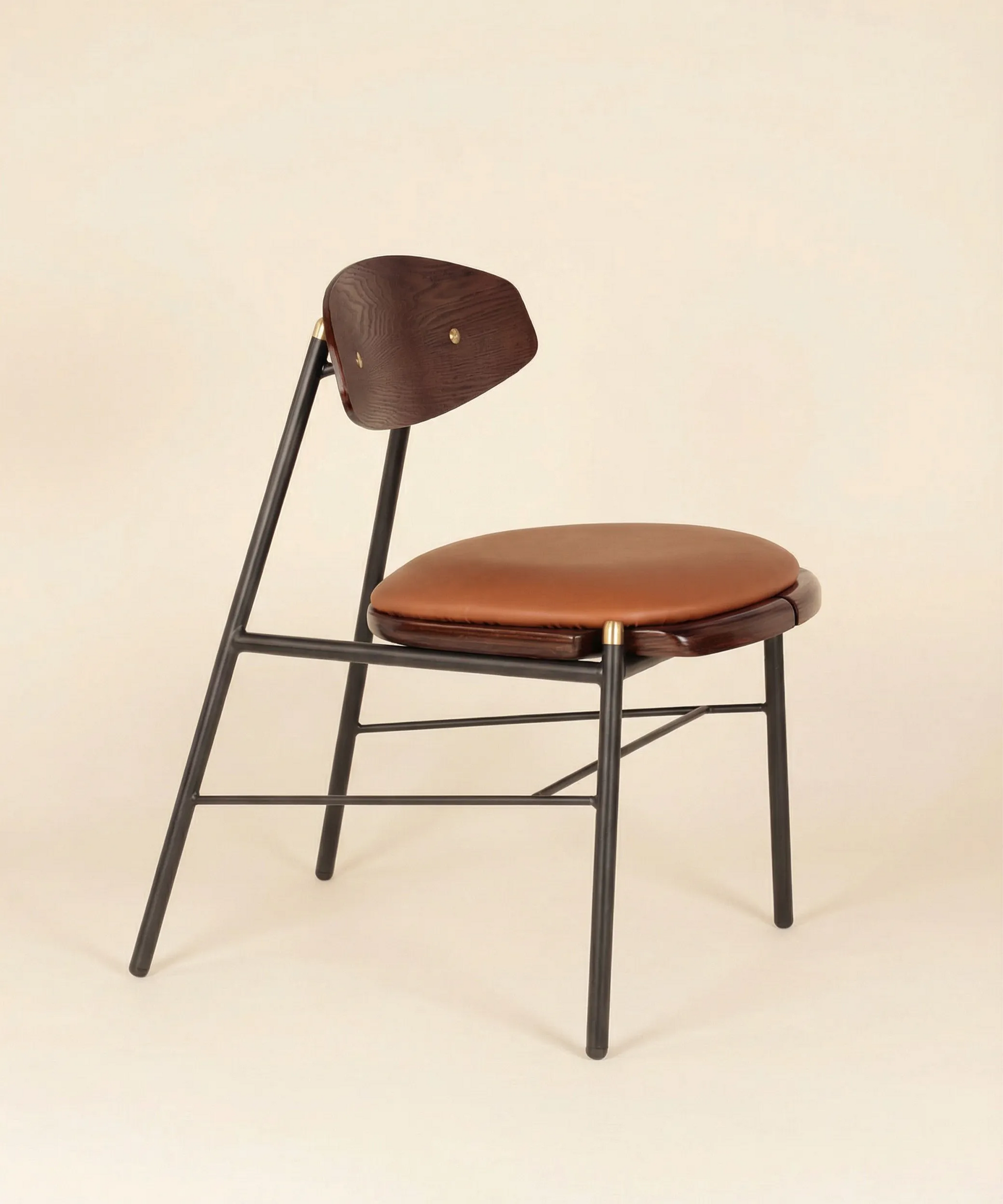 Silla Mocán con respaldo en madera de fresno y estructura metálica negra, diseño moderno para comedor elegante y funcional.