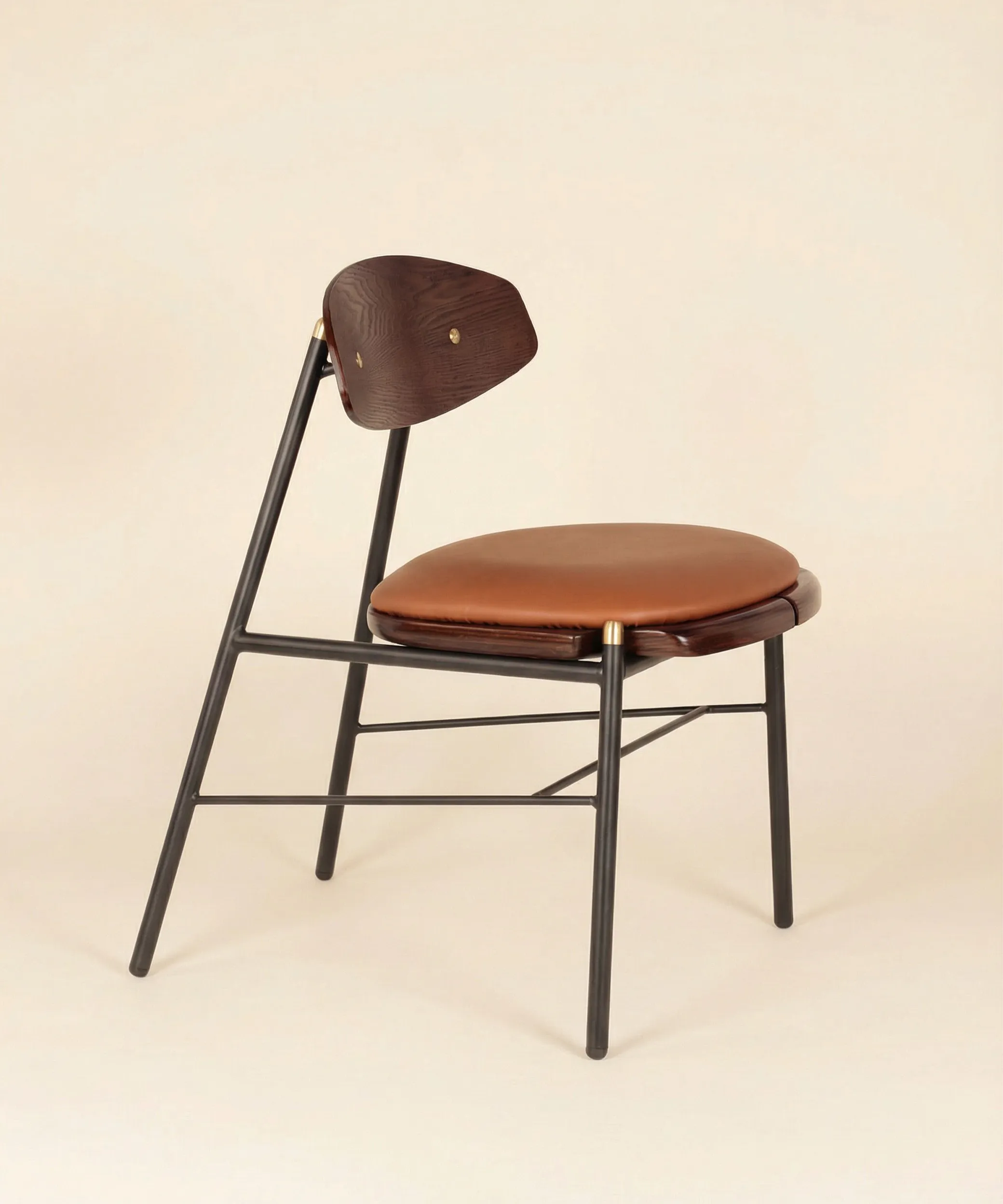 Silla Mocán con respaldo en madera de fresno y estructura metálica negra, diseño moderno para comedor elegante y funcional.