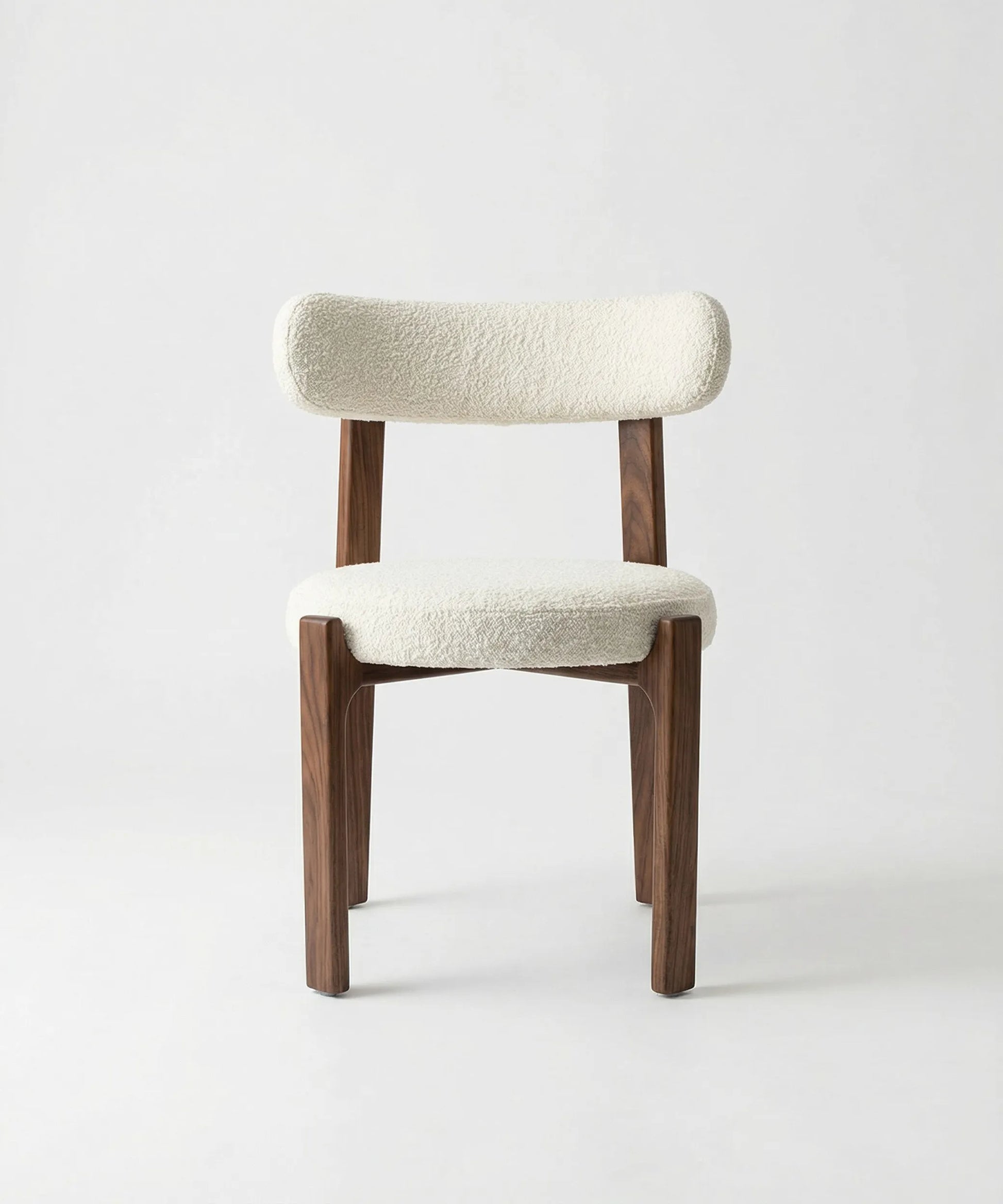Silla Malpica con estructura de madera de fresno y tapizado blanco, diseño contemporáneo y formas suaves y elegantes.