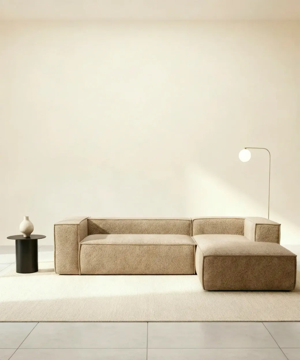 Sala neutra con sofá modular Cinchado en tono beige texturizado acompañado de lámpara y mesa auxiliar minimalistas.