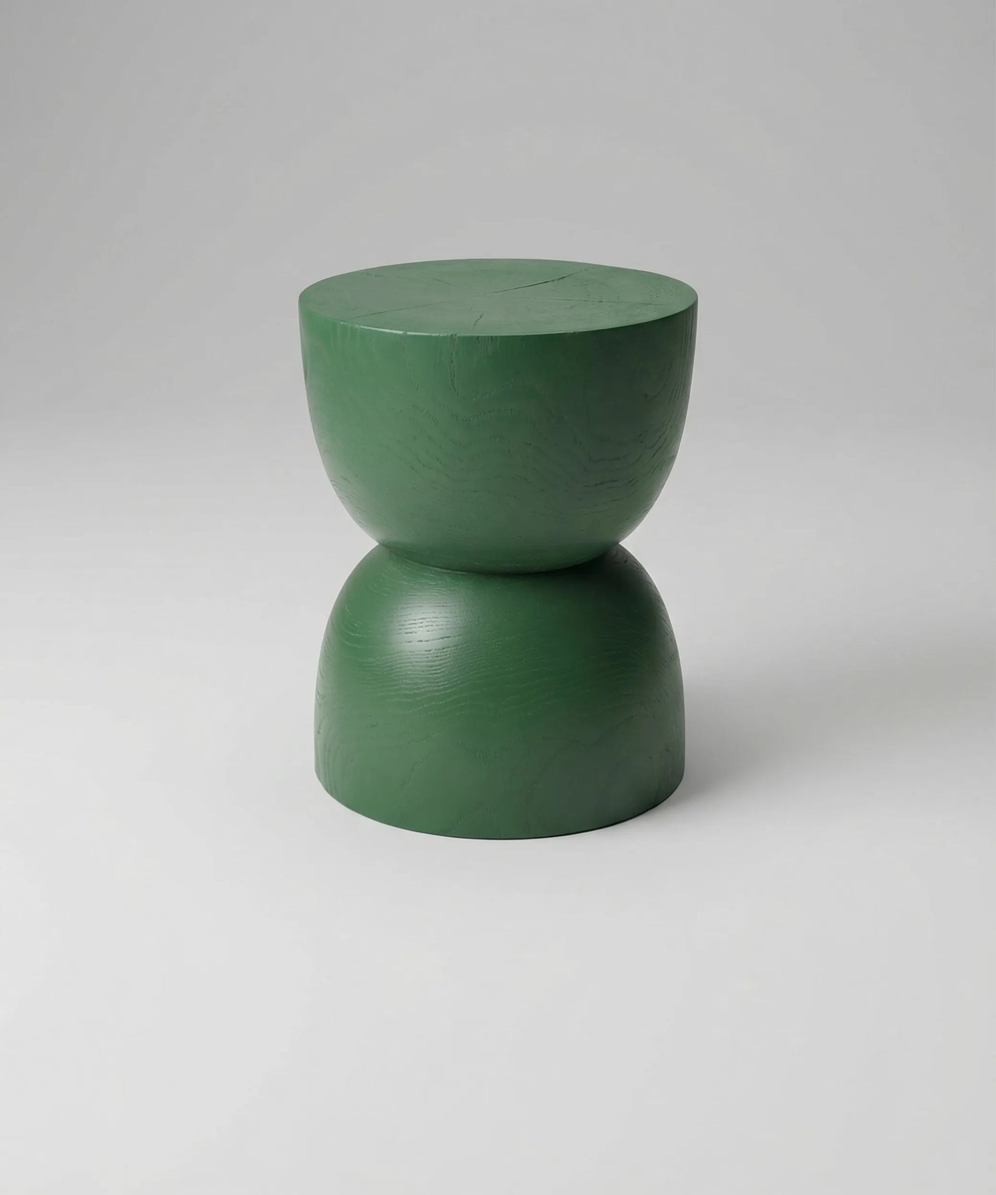 Mesa auxiliar Calima en madera maciza con diseño escultórico y acabado verde profundo para un toque distintivo contemporáneo.