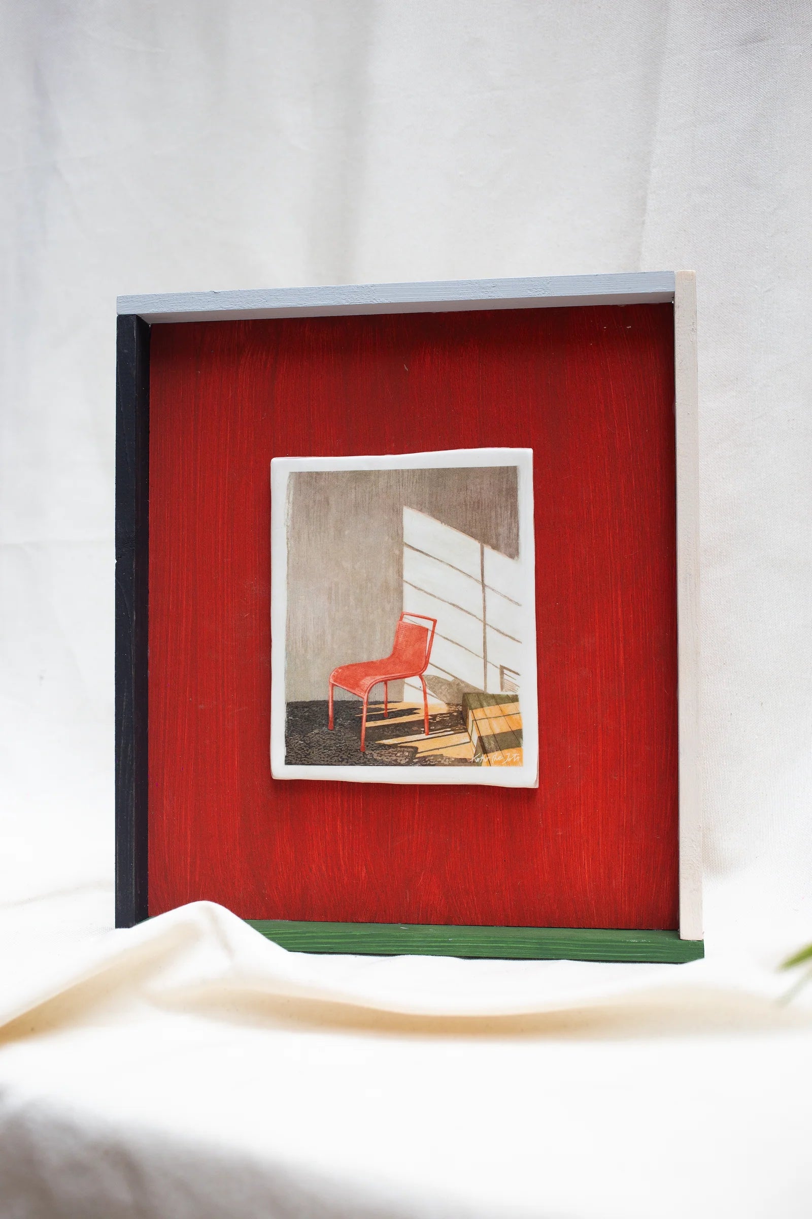 RED SERIE Nº2" // Cuadro de Cerámica con silla roja iluminada por luz natural y fondo rojo intenso.