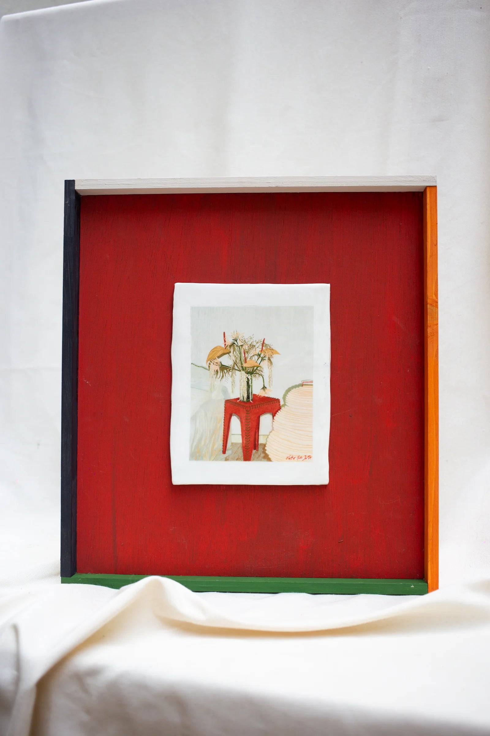 FLOWERS FOR FEIFY" // Cuadro de cerámica con jarrón y flores sobre mesa roja, marco de madera colorido.