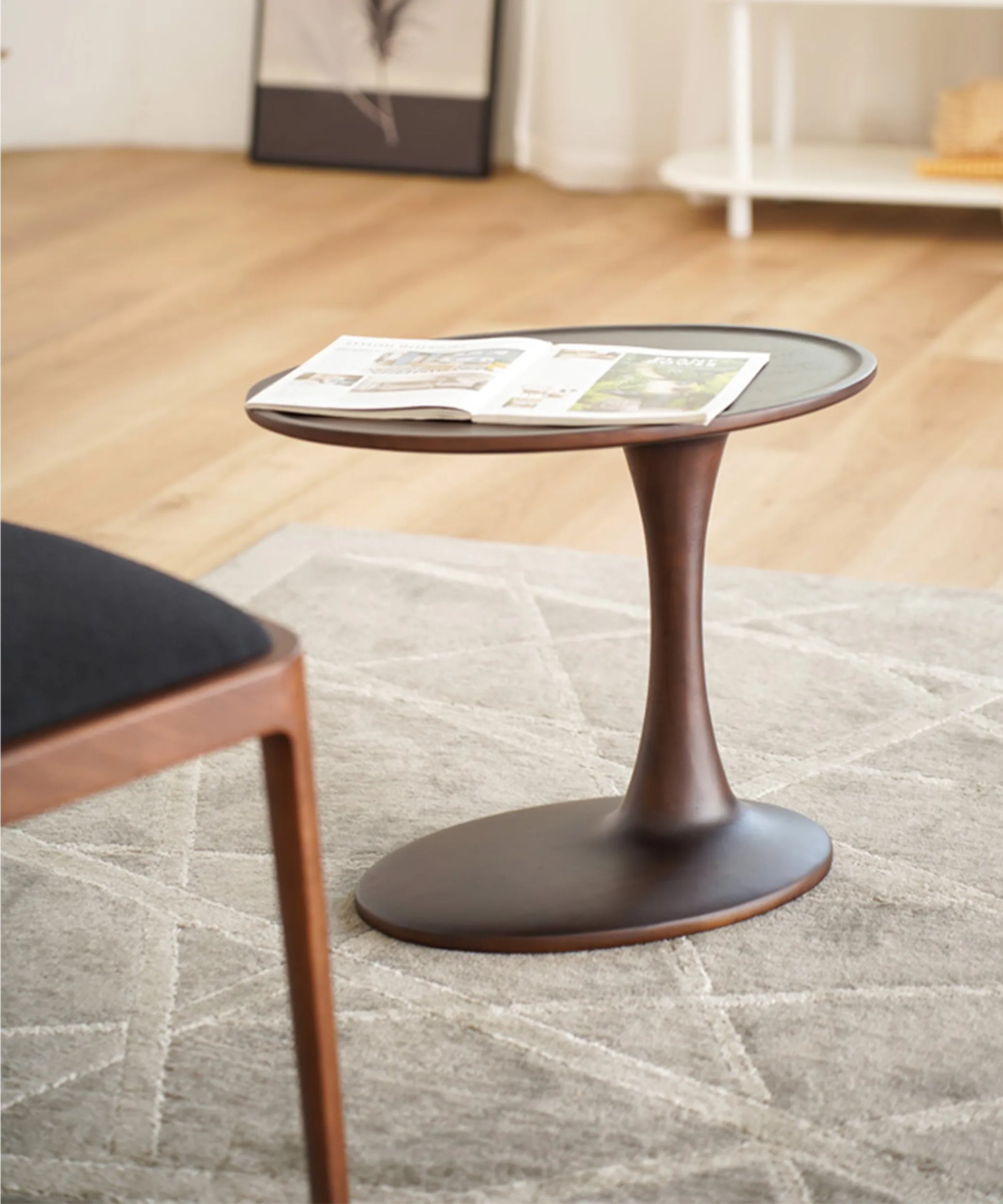 Mesa auxiliar Brisa en madera de fresno nogal oscuro con diseño escultórico y líneas suaves para espacios modernos y elegantes.