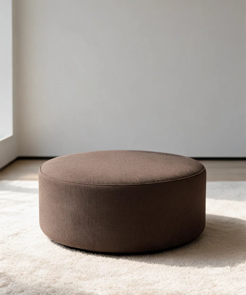 Isleta puff redondo en tono marrón oscuro con diseño versátil y cómodo para salones modernos en Canarias