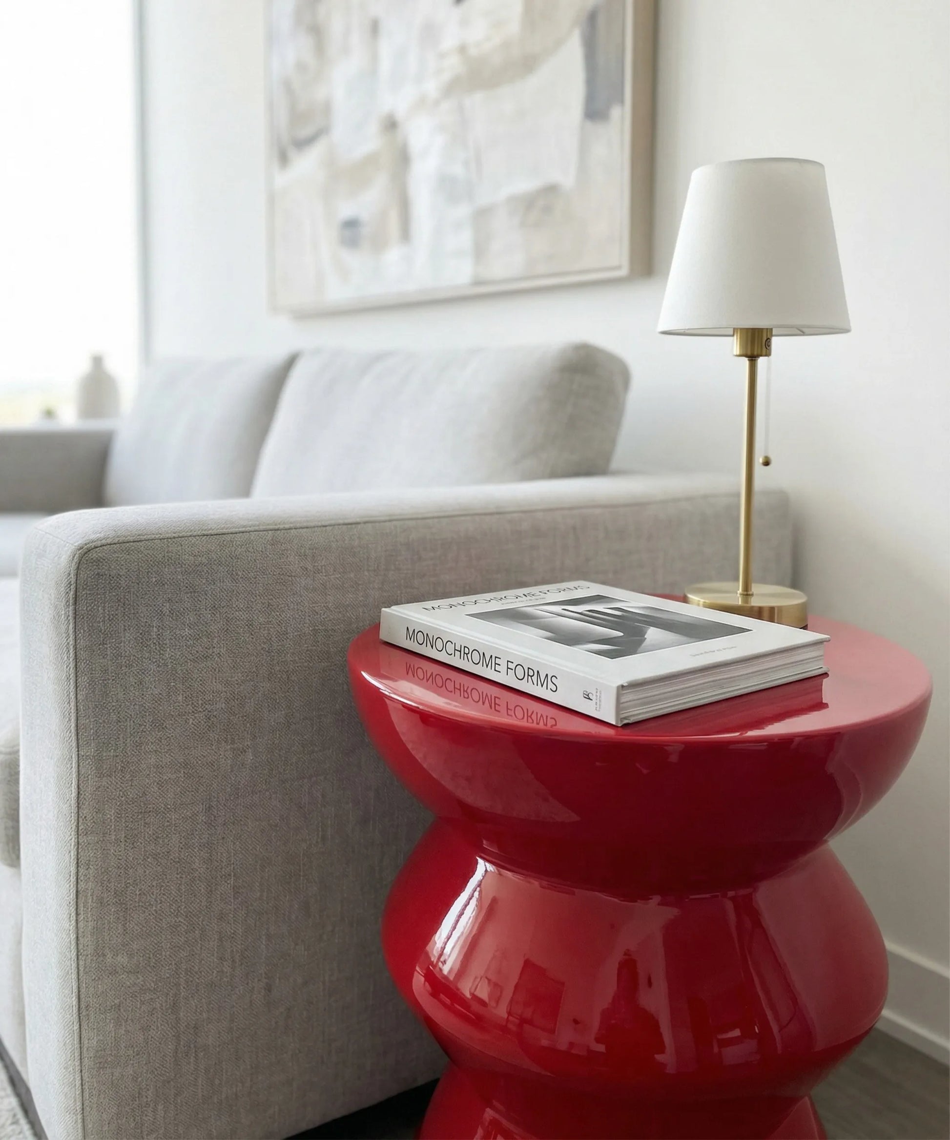 Mesa auxiliar Amanay en fibra de vidrio rojo intenso con diseño escultural, ideal para ambientes contemporáneos y dinámicos.