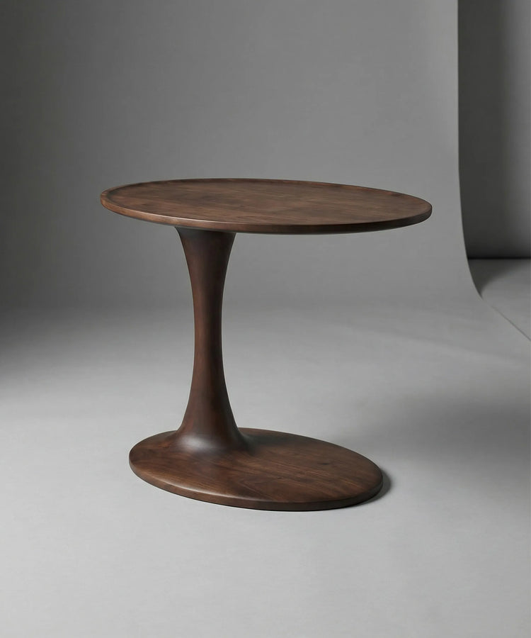 Mesa auxiliar Brisa en madera de fresno con acabado nogal oscuro y diseño escultórico para ambiente contemporáneo elegante