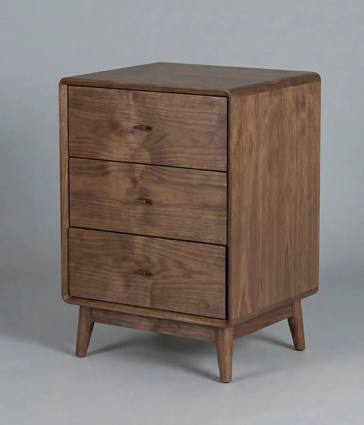 Mesa de noche Nogales en madera de tono natural con tres cajones, diseño elegante y funcionalidad para cualquier dormitorio.