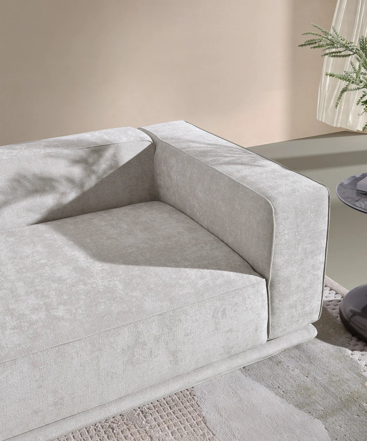 Detalle del brazo y asiento del sofá Palmero en tela gris claro con diseño moderno y estructura robusta.