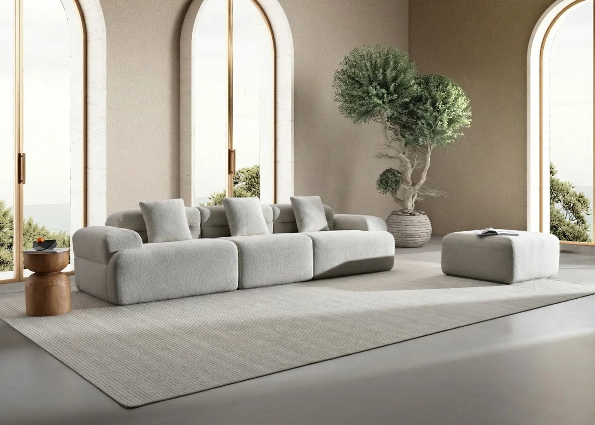 Sofá modular Haría en tono gris con diseño contemporáneo junto a otomana y detalles naturales luminosos.