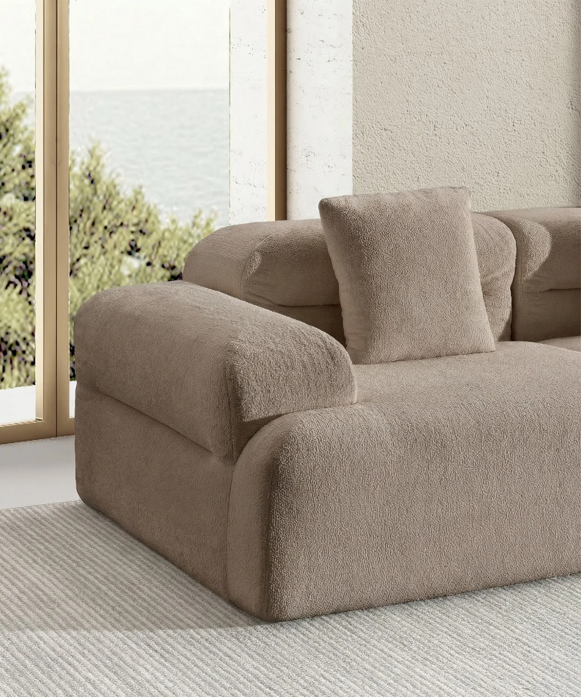 Sofá modular Haría en tono beige con diseño ergonómico y tela suave en un ambiente luminoso y elegante.