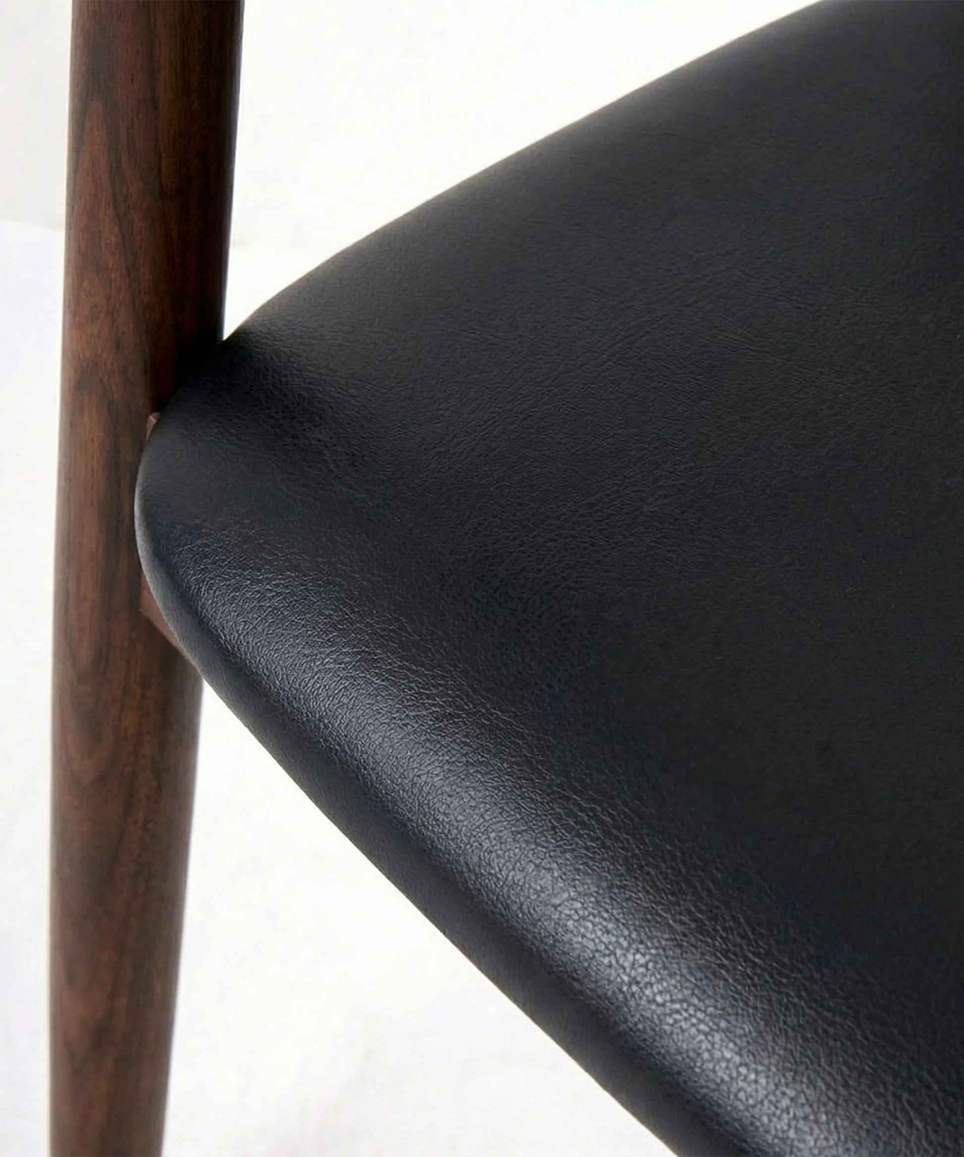 Silla Tabaiba con asiento negro y estructura de madera, diseño contemporáneo y curva ergonómica para mayor confort.