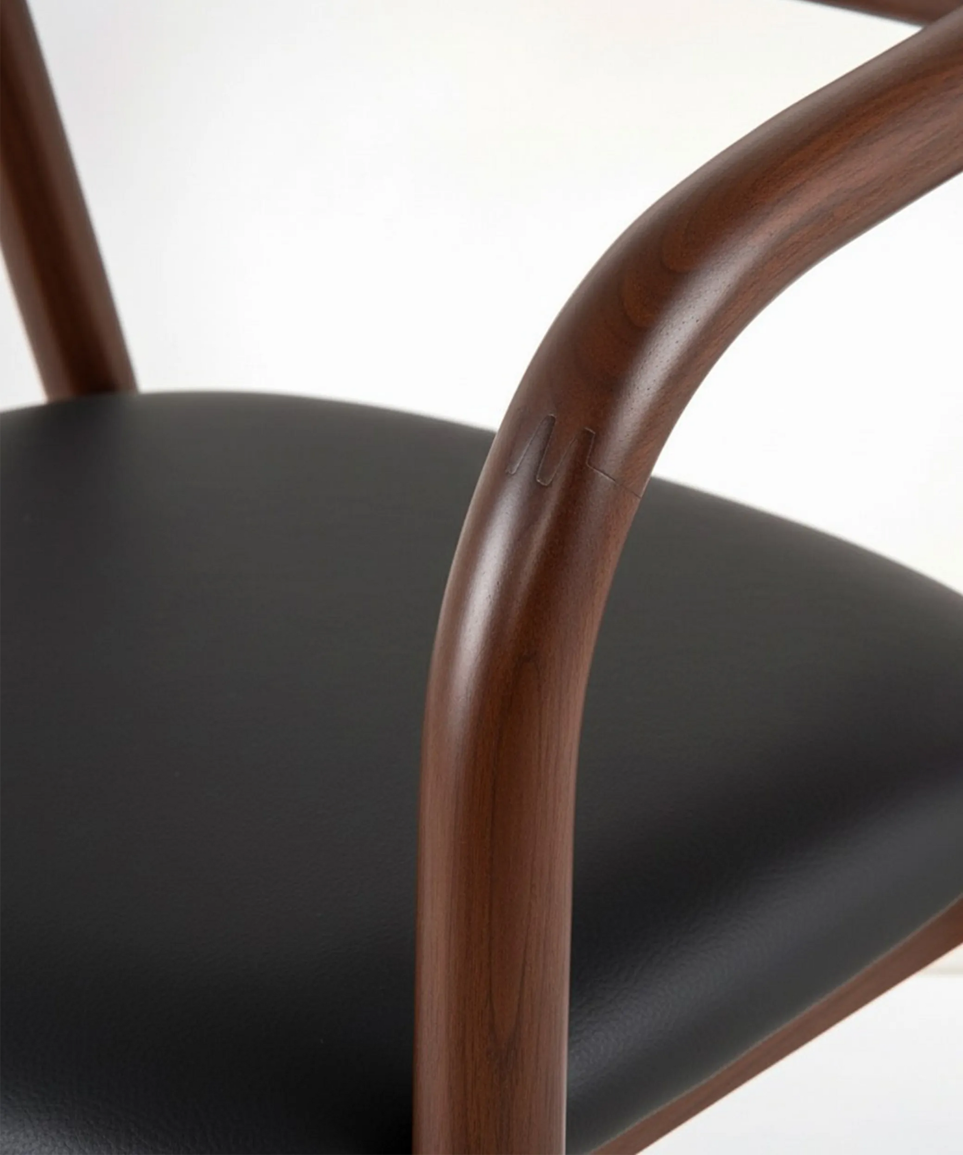 Silla Tabaiba con estructura de madera de fresno y asiento negro, diseño envolvente y elegante para comedor contemporáneo.