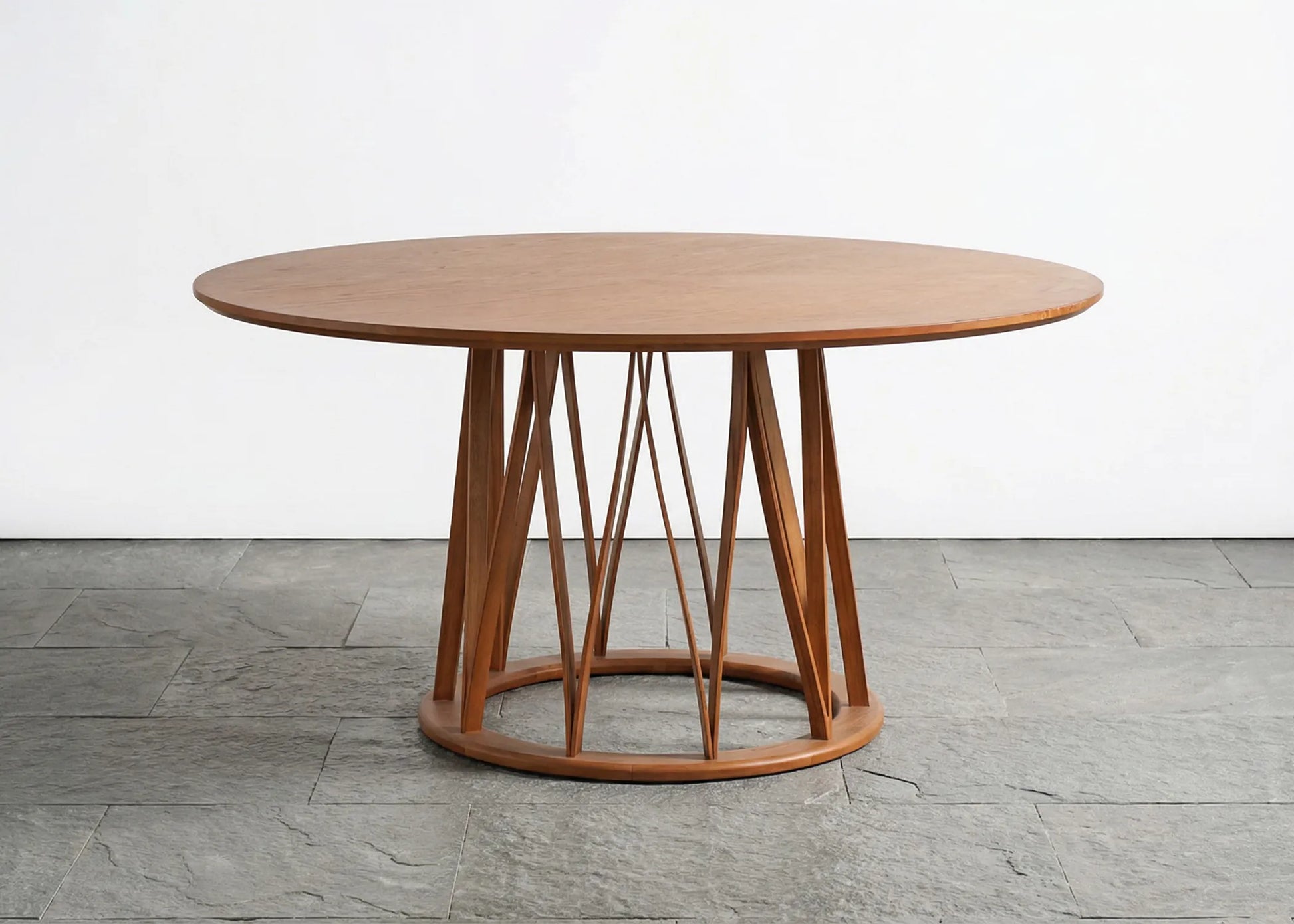 Mesa Fataga redonda en madera de fresno tono café natural con base de diseño contemporáneo elegante y cálido.