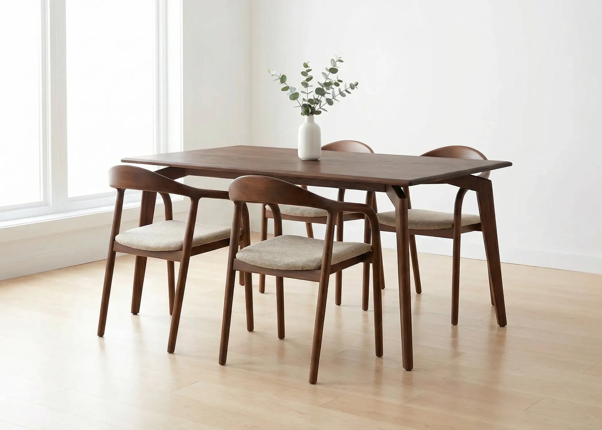 Mesa Tirajana de madera fresno con acabado nogal oscuro y diseño elegante junto a sillas tapizadas beige.