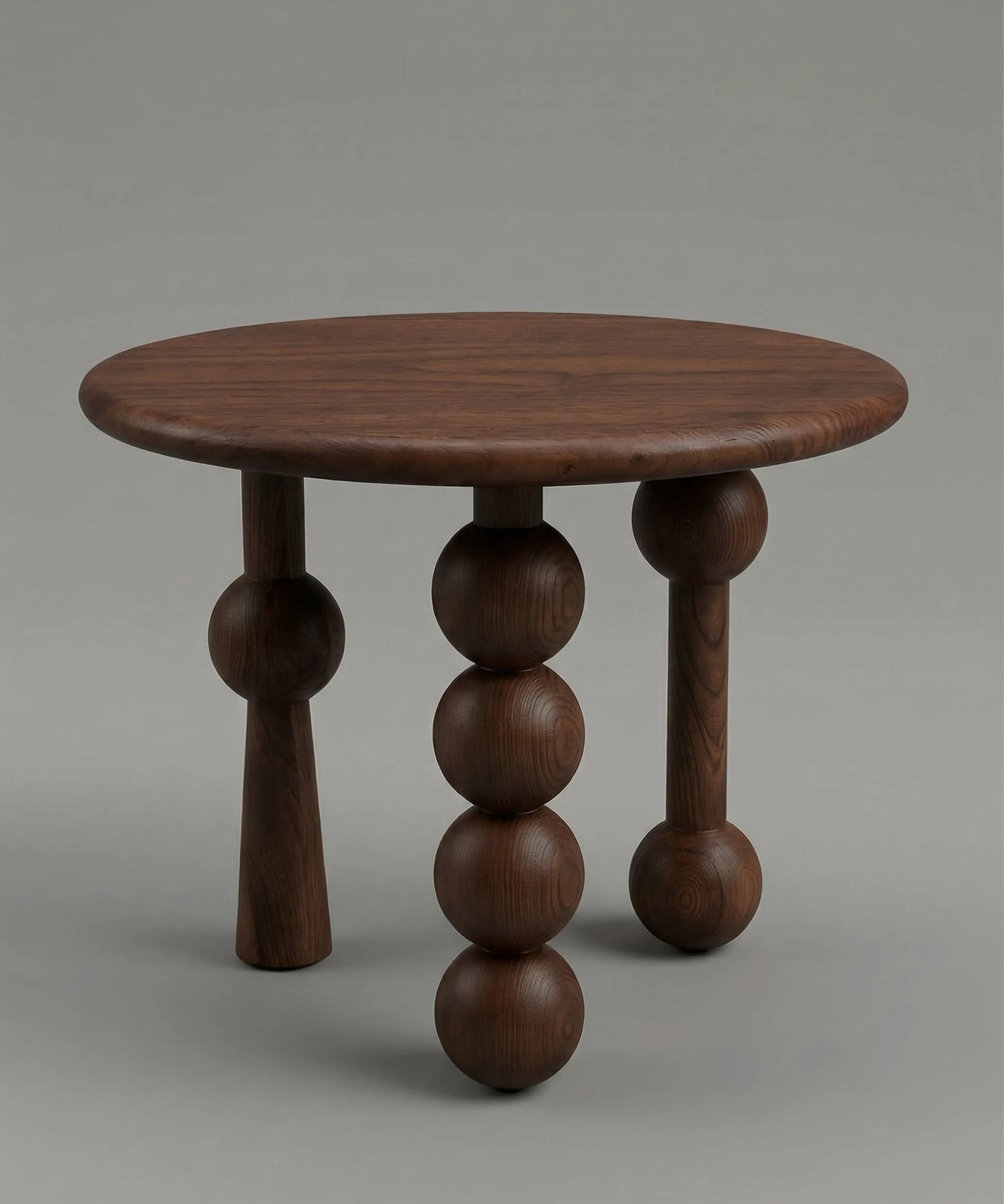 Mesa auxiliar Niebla en madera de fresno tono café con diseño escultórico y patas esféricas distintivas.