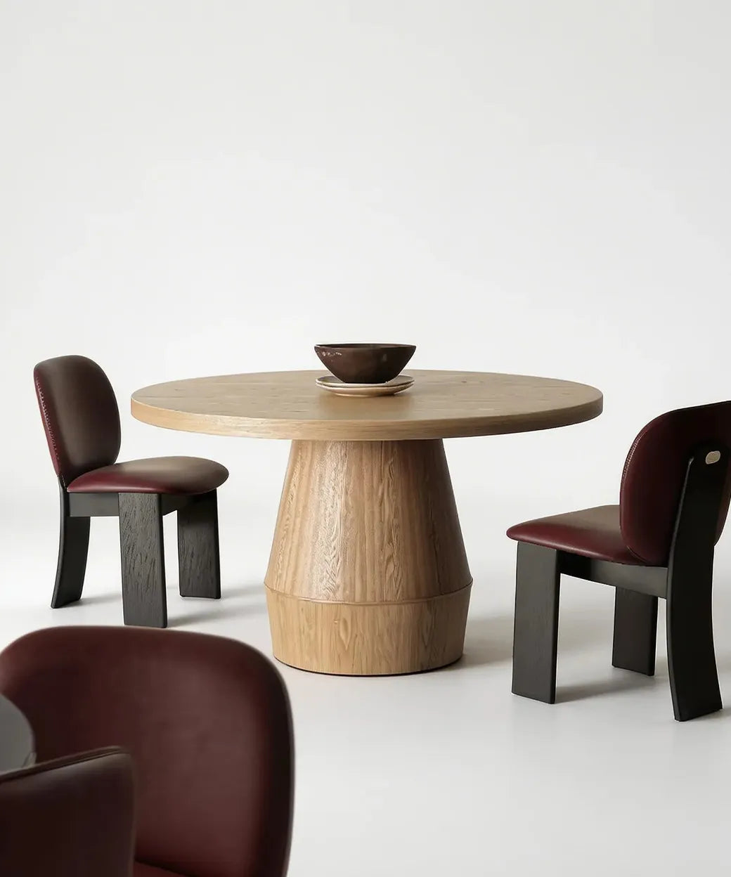 Tagoro en madera clara con base cilíndrica que aporta solidez y estilo contemporáneo al comedor minimalista