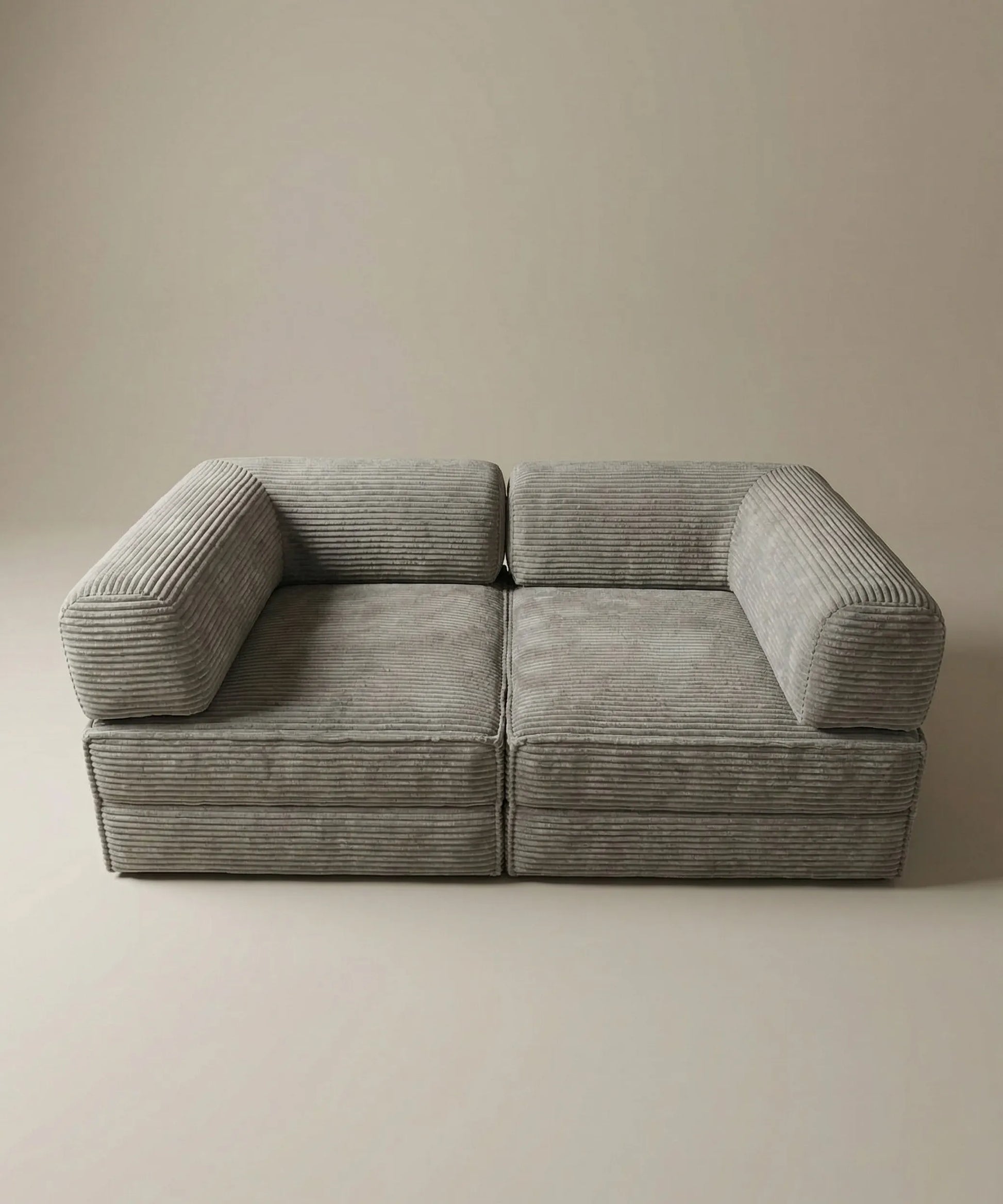 Sofá modular Alisios en tono gris, diseño contemporáneo con textura acolchada y estilo minimalista elegante.